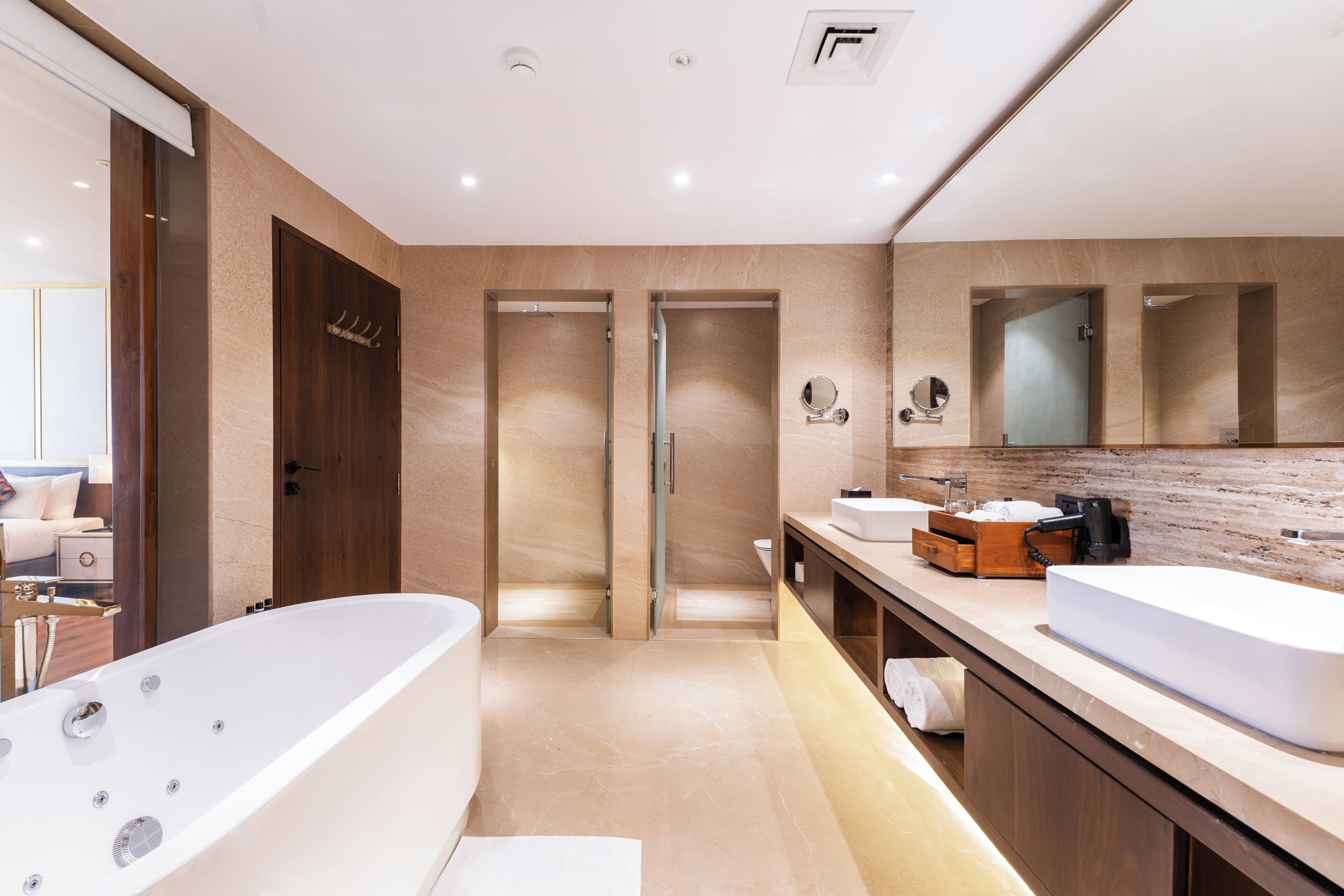 A modern bathroom with a freestanding bathtub, a double vanity with two sinks, and a large mirror above the vanity.