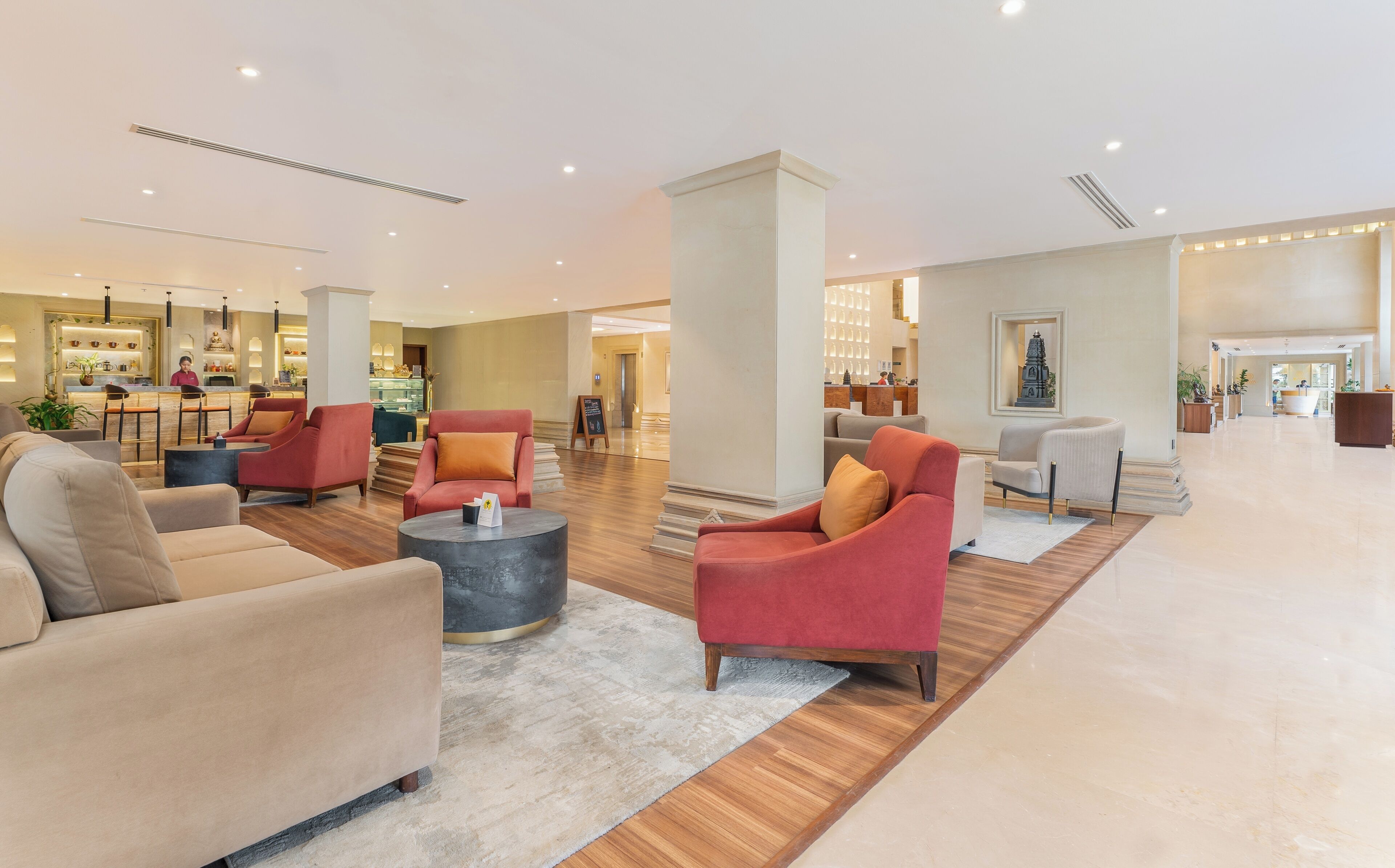 A spacious lobby with seating areas, a reception desk, and a bar.