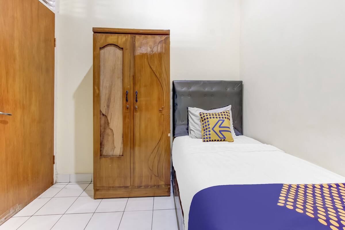 A bedroom with a bed, a wardrobe, and a nightstand.