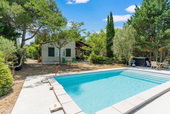 Une piscine rectangulaire à l’eau d’un bleu limpide, entourée d’une terrasse dallée.