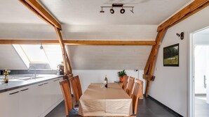 A dining area with a table set for six, wooden chairs, a white tablecloth, and a potted plant. - Cottage on sheep farm with gelateria (Merksplas)