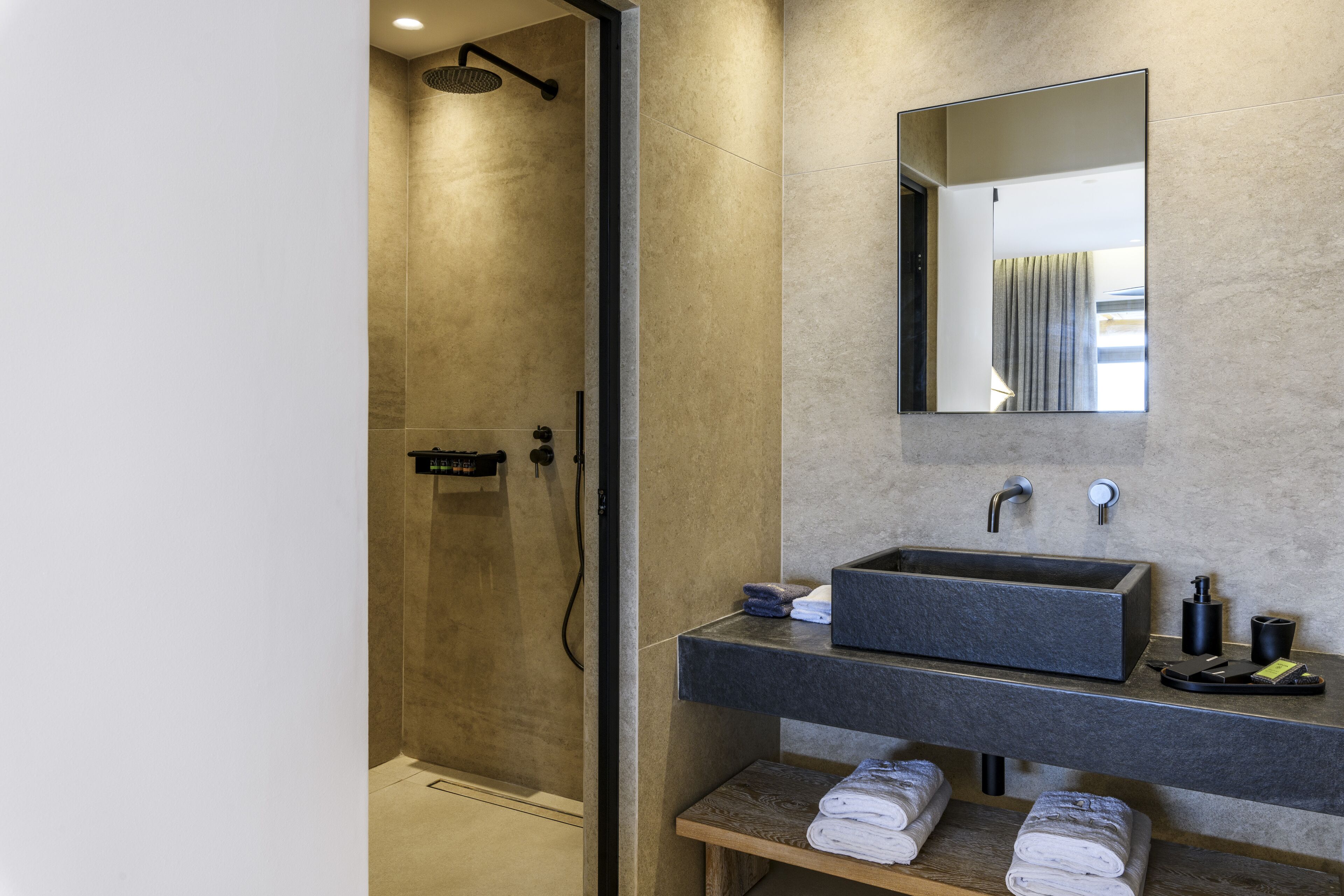 Un bagno moderno con doccia vetro-muraria, uno specchio grande e un mobile doppio lavabo.