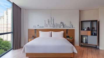 Una habitación de hotel moderna con una cama grande, cabecera de madera y un mural con vistas a la ciudad.