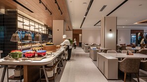 Un restaurante moderno con una barra larga, varias estaciones de servicio y un interior limpio y contemporáneo.