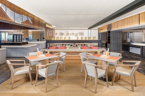 Un restaurant moderne doté d’une salle à manger centrale, de lambris en bois et d’un comptoir avec une vitrine.