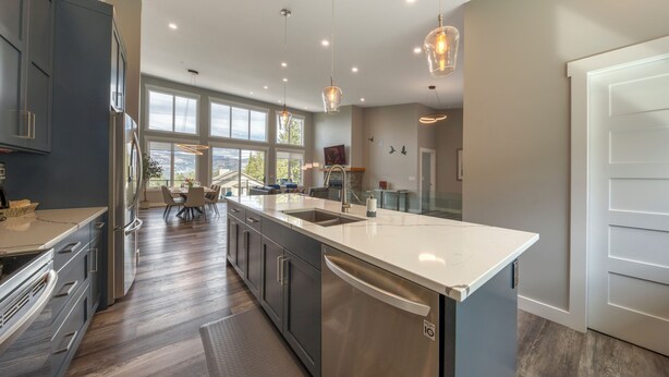 A modern kitchen with a large island, stainless steel appliances, and pendant lighting. - Fairmont Peak Cabin | Pet Friendly | Pool Table (Area F (Columbia Lake/Windermere Lake))