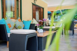 A modern outdoor seating area with wicker furniture and colorful cushions. - Pension Michel - Villa Roche Bois (La Digue)