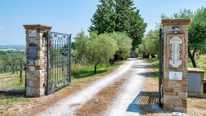 A stone gate with a metal gate, a sign with 'Welcome Casafonacchi,' and a path leading through an olive grove. - Farmhouse 'Casale Storico Xvii Sec - Tulipano' with Mountain View and Shared Pool (Giano dell'Umbria)