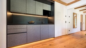 Eine moderne Küche mit eingebauten Schränken, einer Edelstahlspüle und Holzboden.