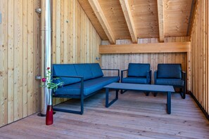 Puisesti sisustettu tila, jossa on sohva, kaksi tuolia ja pöytä.