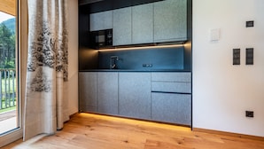 Une cuisine moderne avec des meubles gris, un four à micro-ondes et un évier.