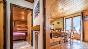 Un intérieur en bois comprenant un lit, une table à manger et une cheminée.