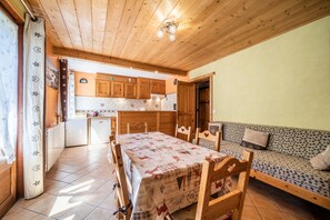 Une cuisine chaleureuse avec des meubles en bois, une table à manger et un canapé.