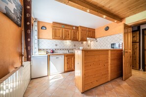 A kitchen with wooden cabinets, a dishwasher, a microwave, and a tiled backsplash.
