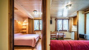 Een houten chalet met twee slaapkamers, een eetgedeelte en een keuken.