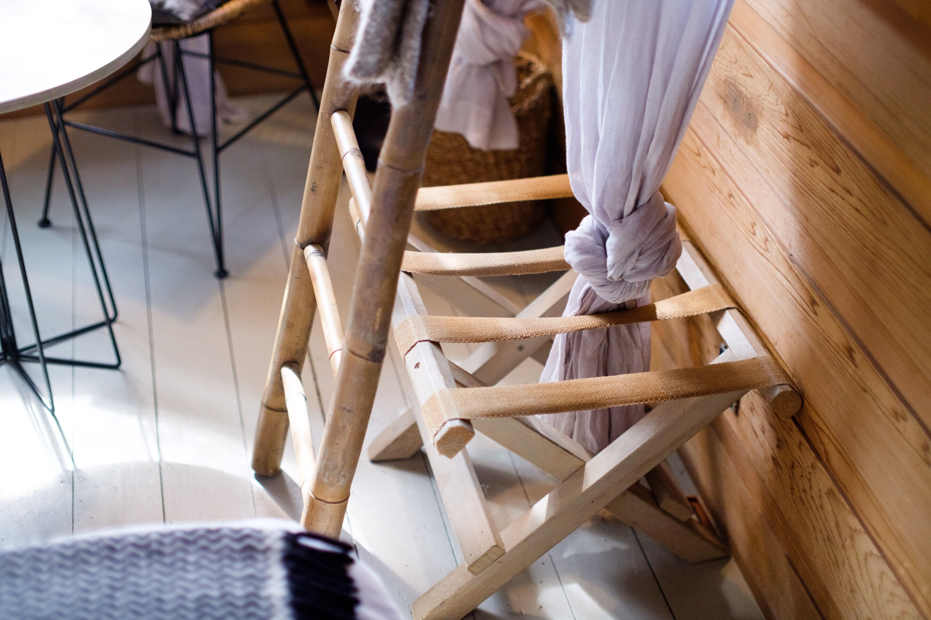 Une chaise en bois, dotée d’un siège et d’un dossier en osier, placée contre un mur en bois.