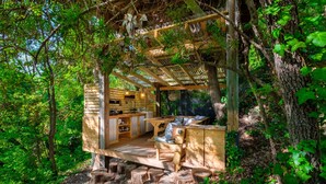Een houten chalet met terras, inbouwkasten en een pergola.