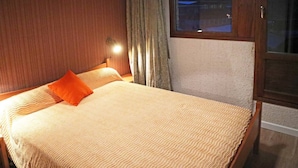 A hotel room with a bed, a nightstand, a window, and a door. - 834 Orrianes des Forets (LES ORRES 1650)