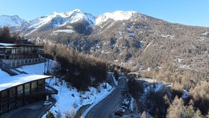 A mountain lodge with a road leading up to it, surrounded by snow-covered mountains. - 834 Orrianes des Forets (LES ORRES 1650)
