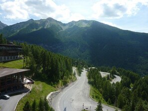Una carretera de montaña con un edificio a la izquierda.