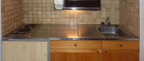 Een koelkast, kookgerei, borden en bestek