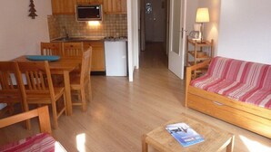 A compact living space with a kitchenette, a dining area, and a seating area.