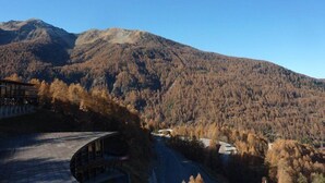 Paisatge de muntanya amb una carretera que condueix a un edifici amb teulada corbada.