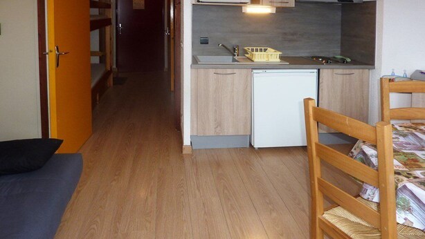 A compact room with a kitchenette, a small refrigerator, a microwave, and a wooden chair. - 603 Balcon des Orres (LES ORRES 1650)