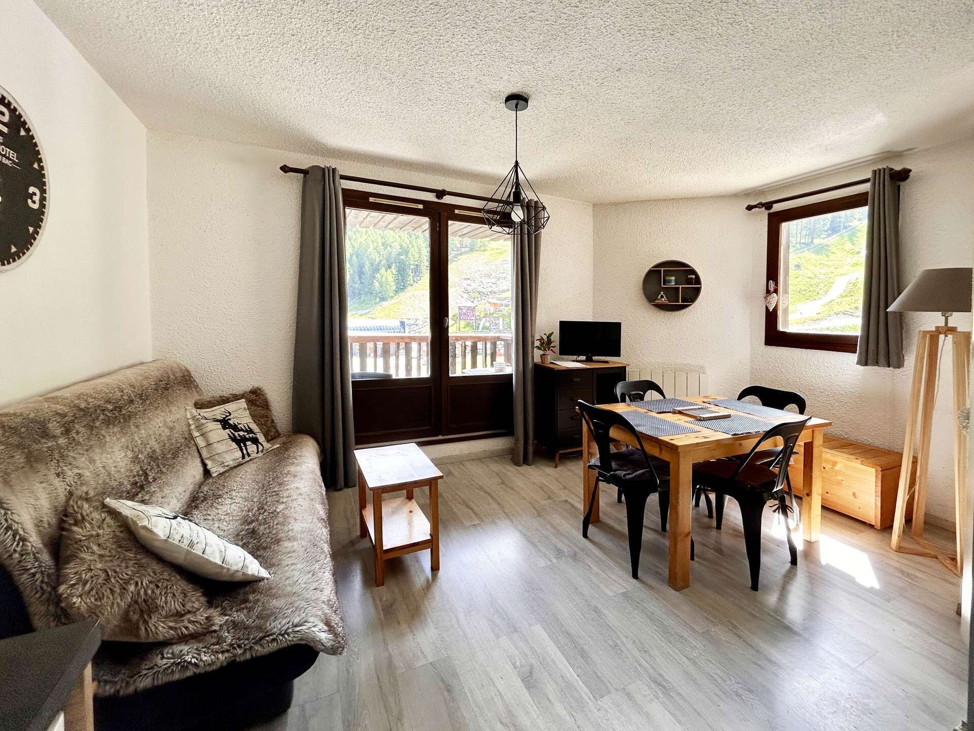 A cozy living room with a sofa, a dining table, and a TV.
