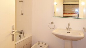Ein Badezimmer mit Badewanne, Waschbecken und Dusche.