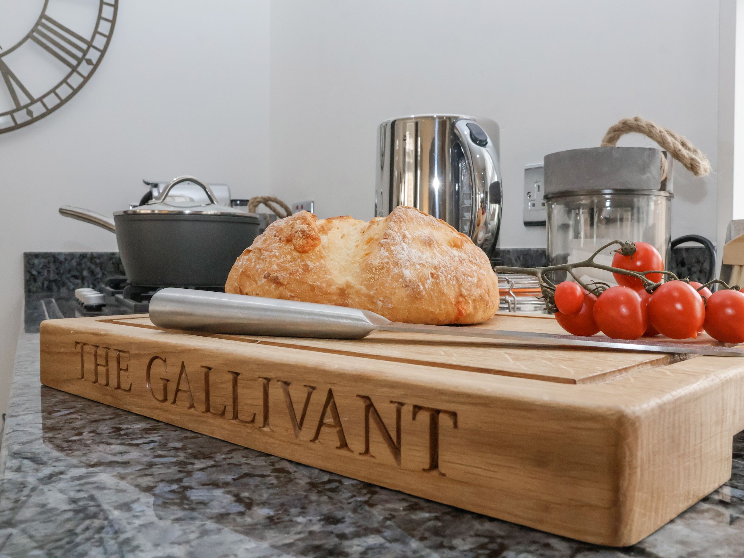 Une planche à découper en bois portant l’inscription « THE GALLIVANT » sur un plan de travail de cuisine.