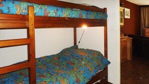 Ein Etagenbett mit Blumenoptik in einem Zimmer mit Holzboden und Schreibtisch.