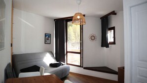 Ein Zimmer mit einem Bett, einem Tisch und einem Fenster.