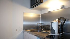 Eine kleine Küche mit Spüle aus Edelstahl, einer Mikrowelle und einer Kaffeemaschine.