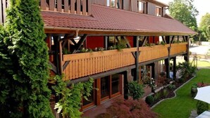 A two-story building with a wooden balcony and a red-tiled roof. - HÔTEL À LA FERME (Osthouse)