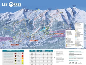 A ski resort map with marked ski trails, lifts, and mountain peaks.