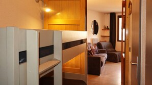 Una habitación con literas, un sofá y un espejo.