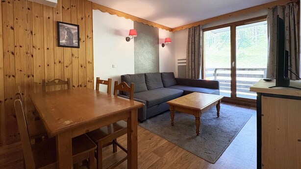 A cozy living room with a wooden dining table, two sofas, and a coffee table.