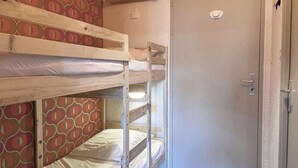 A bunk bed room with a door and patterned wallpaper. - Studio à Deux pas du Centre (LES ORRES 1650)