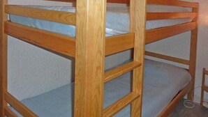 Un lit superposé avec une structure en bois et une literie bleue.