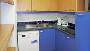 A compact kitchen with a dishwasher, a sink, and a coffee maker. - Appartement Parc DES Airelles 211 (LES ORRES 1800)