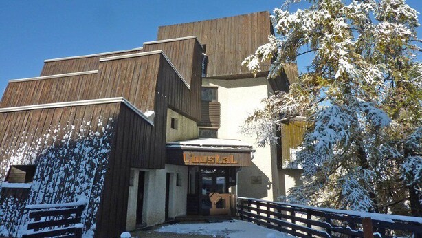 A building with a wooden facade and a sign reading "Coustal." - Grand Studio 4 Personnes (LES ORRES 1650)
