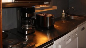 Eine moderne Küche mit Mikrowelle, Kaffeemaschine, Toaster und Geschirrspüler.