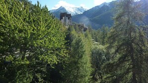 A mountainous landscape with a building nestled among trees.