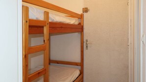 A bunk bed with a door to the right. - Studio Pour 4 Personnes Rénové Avec Soin (LES ORRES 1650)