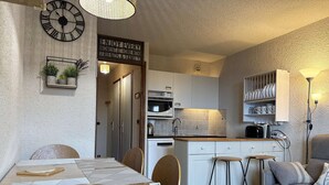 A compact living space with a dining area, kitchen, and seating area.