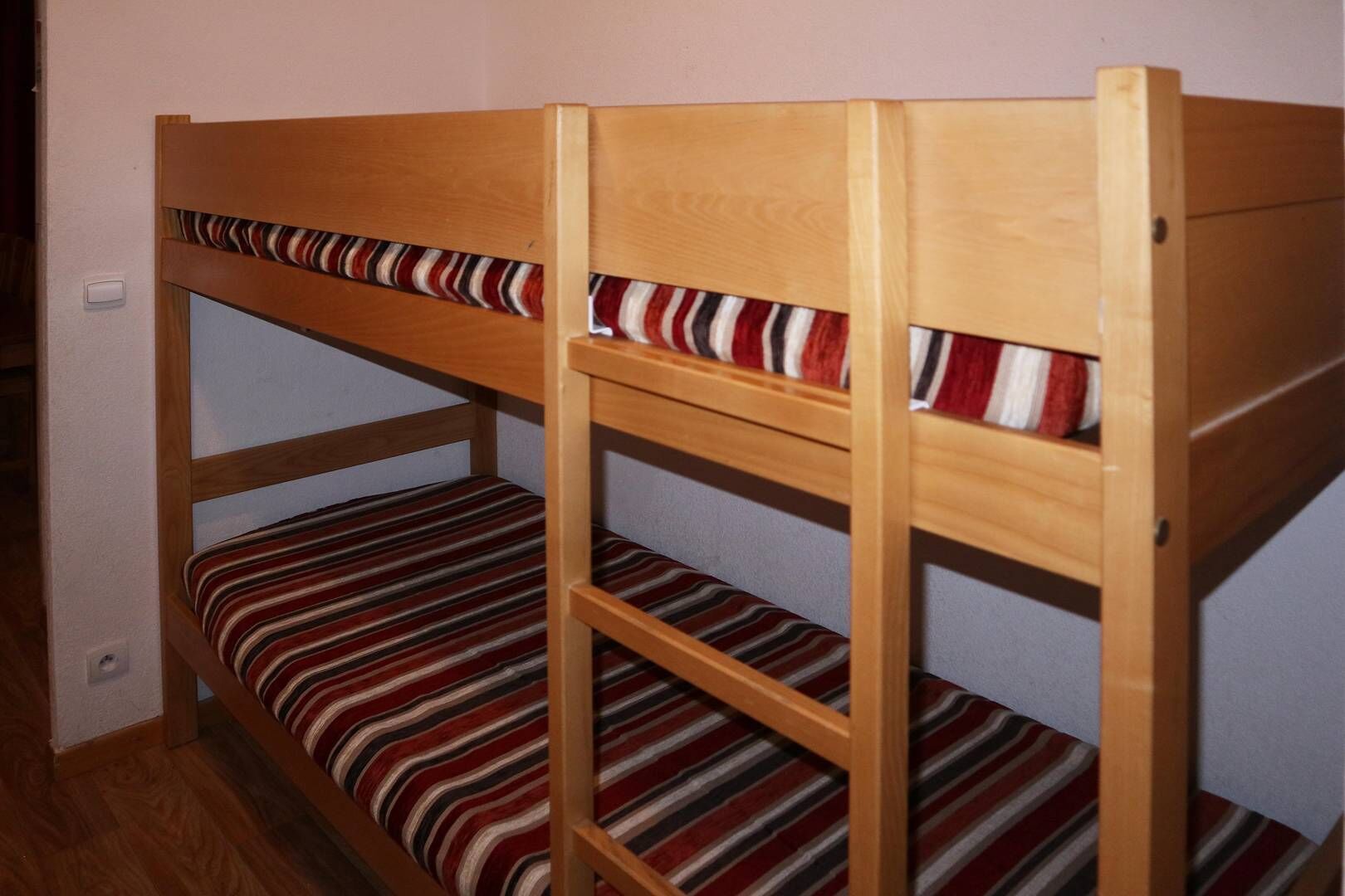 A bunk bed with striped bedding.