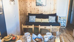 Een knus interieur met een houten bed, een klein tafeltje met ontbijtspullen en een aan de muur bevestigd schilderij.