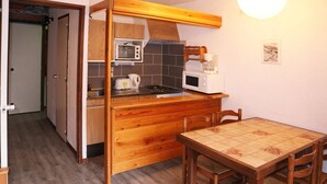 A compact kitchen with wooden cabinetry, a microwave, a toaster, and a coffee maker.