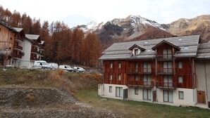 A wooden lodge with multiple balconies and a mountain backdrop.
